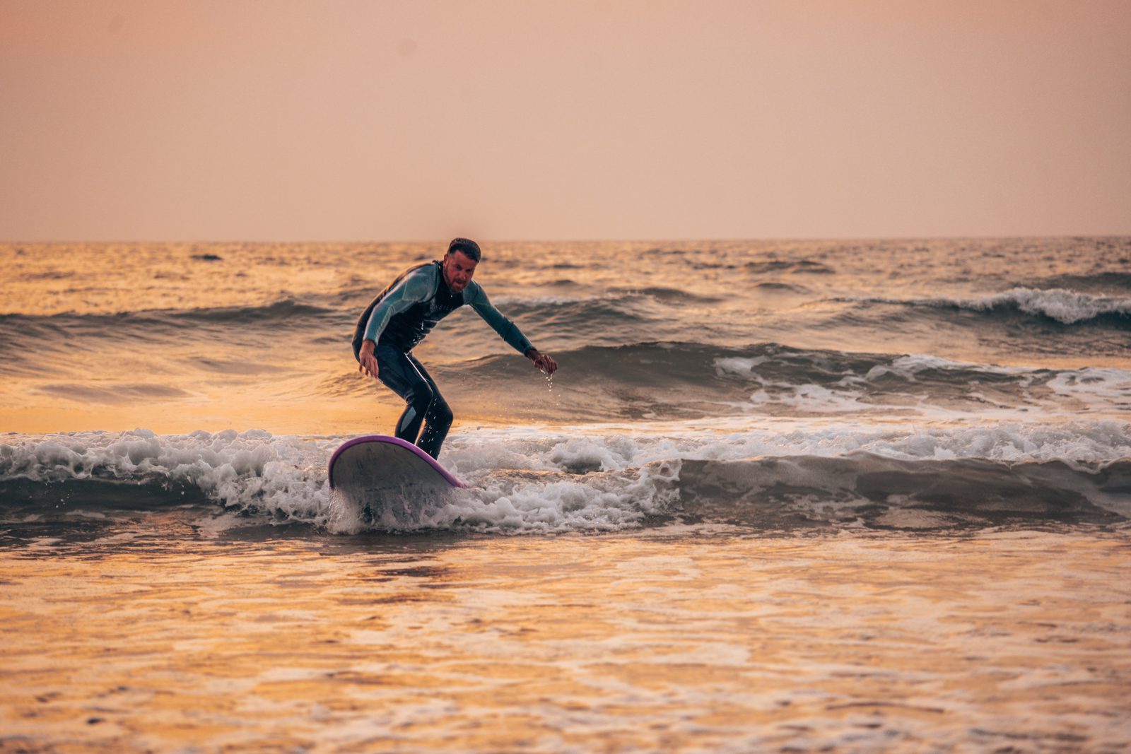 Surfen terwijl de zon opkomt